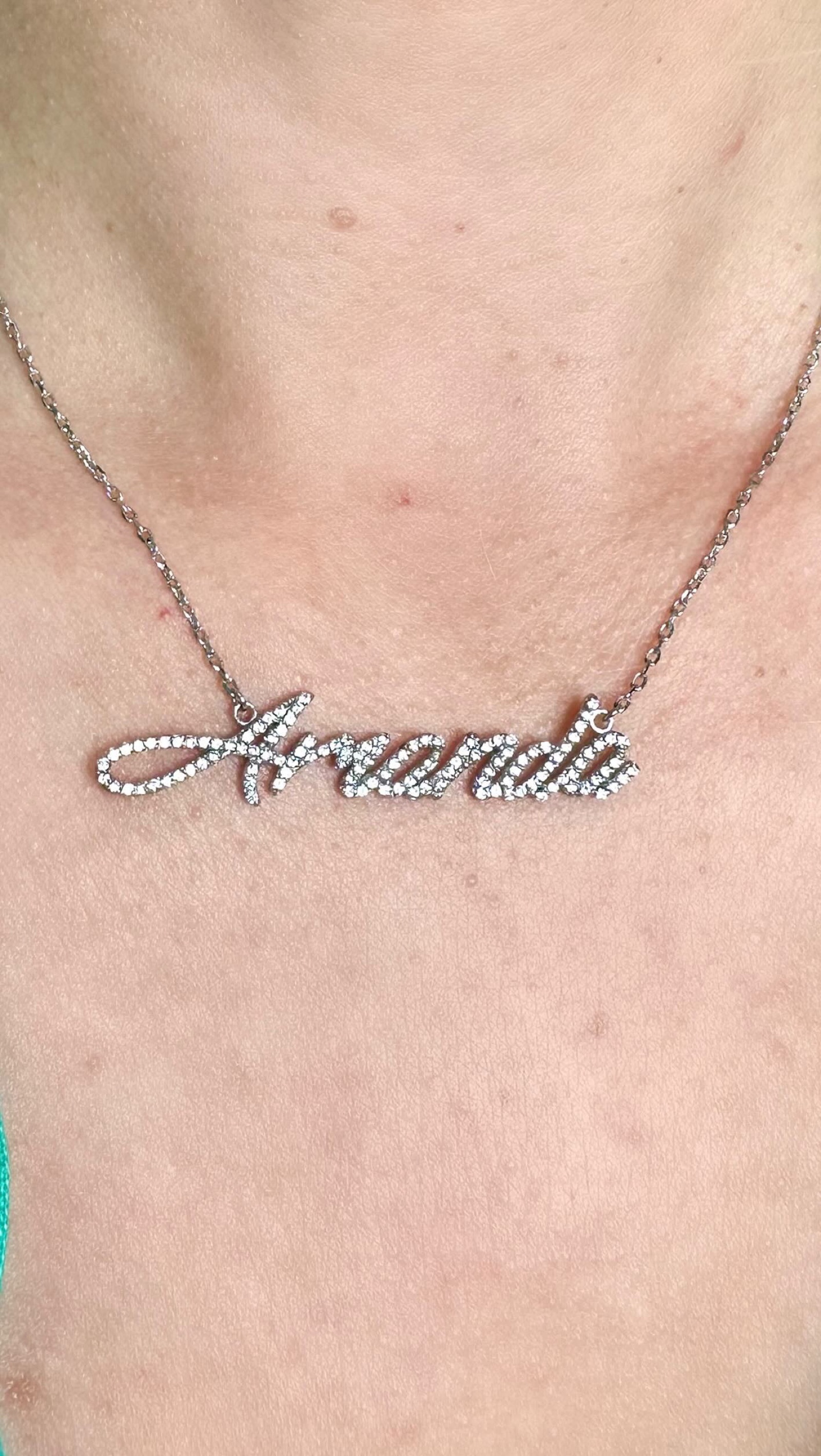 A diamond script nameplate necklace reading Amanda